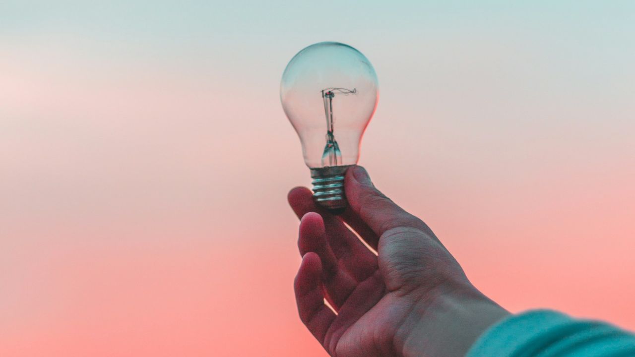 a hand holding a light bulb